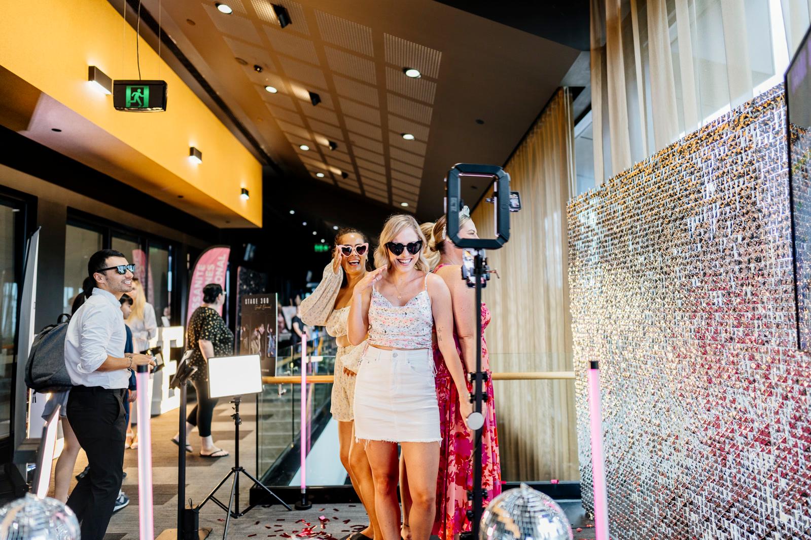 Guests celebrating in front of a sequin wall, captured by the Stage360 photographer